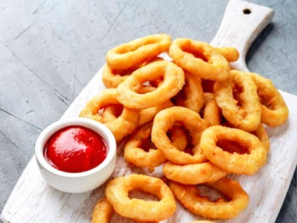 Anelli di cipolla fritti con una ciotolina di ketchup